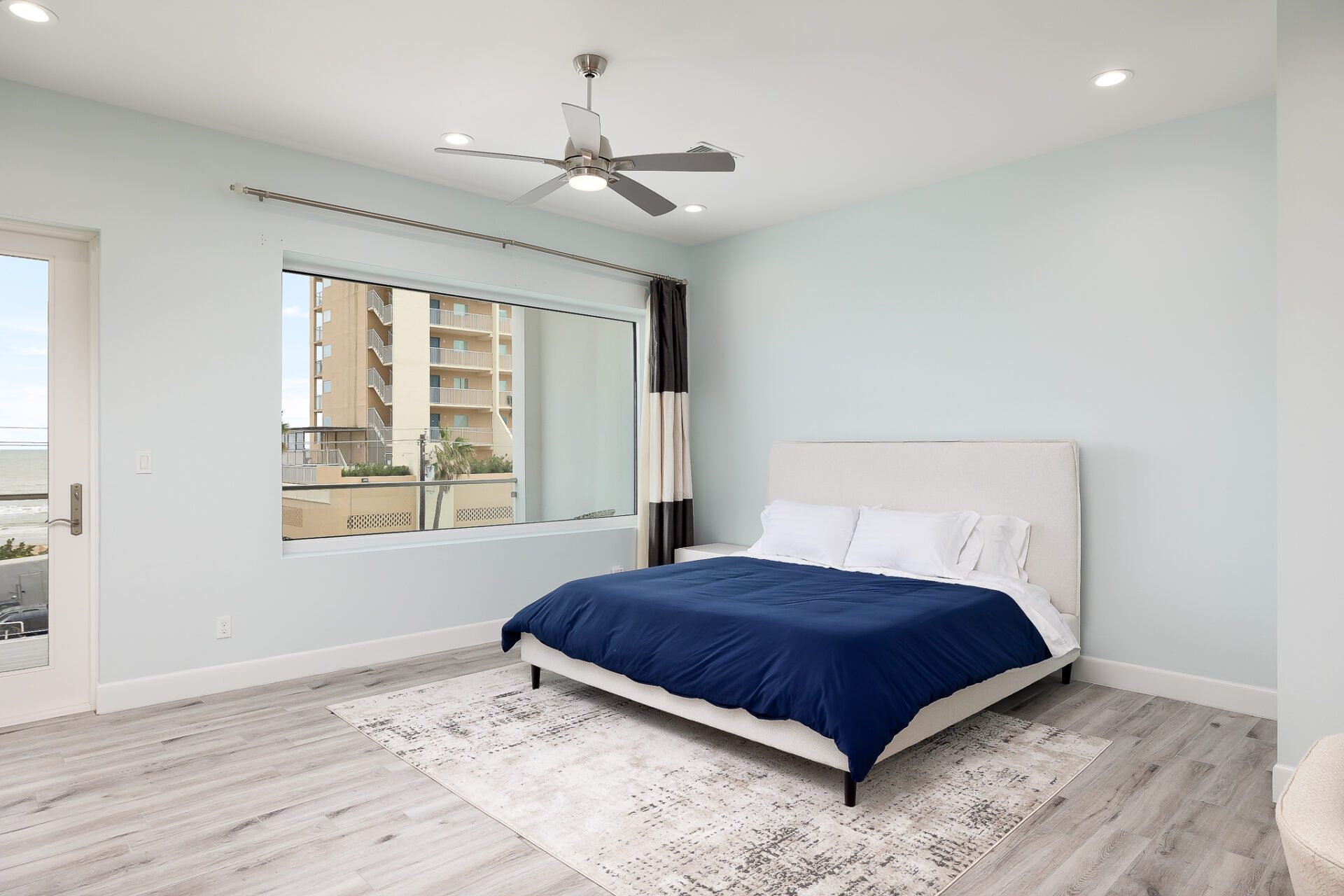 A white bedroom with blue sheets