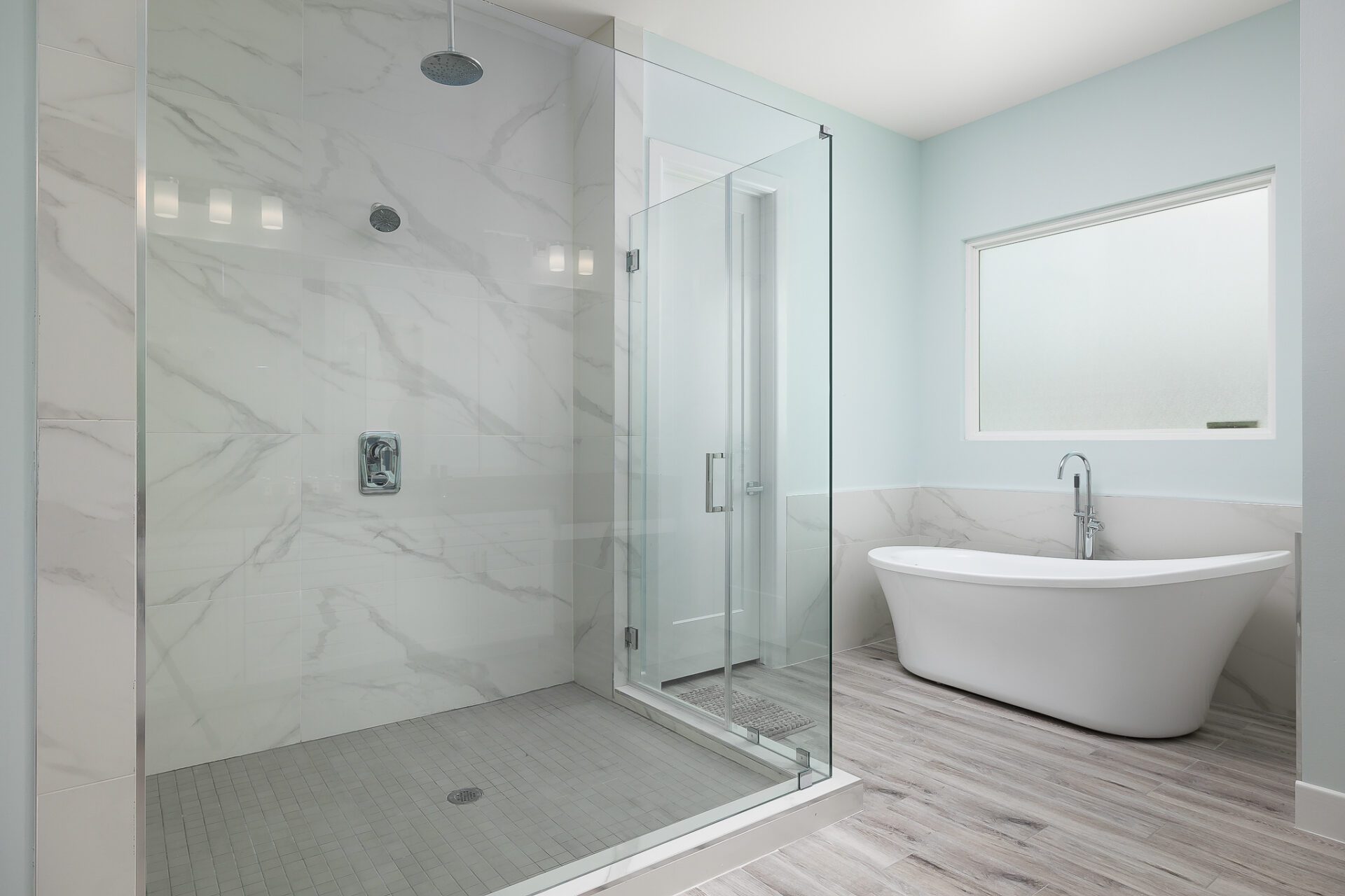 A white bathtub and glass shower doors